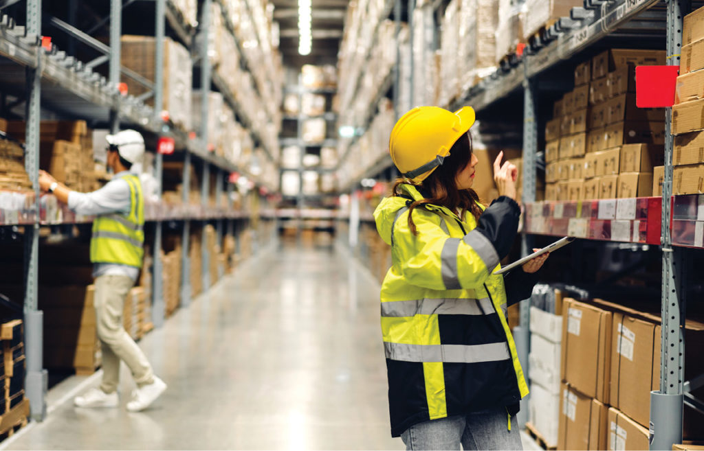 Warehouse setting with smiling female engineer in helmet