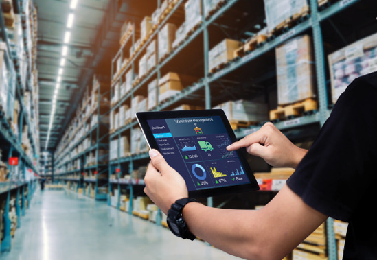 Worker hands holding tablet on blurred warehouse as background