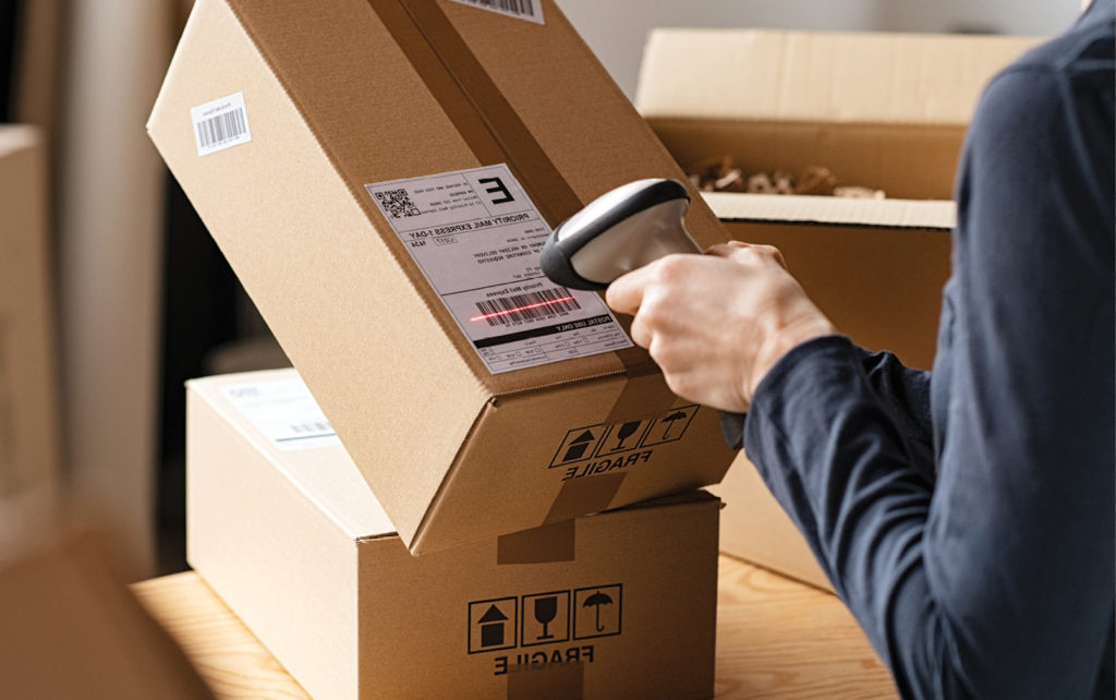 Hands scanning barcode on delivery parcel