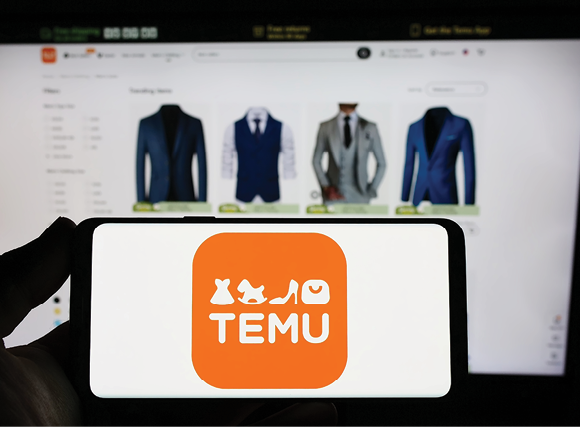 Person holding smartphone with logo of online shop company Temu